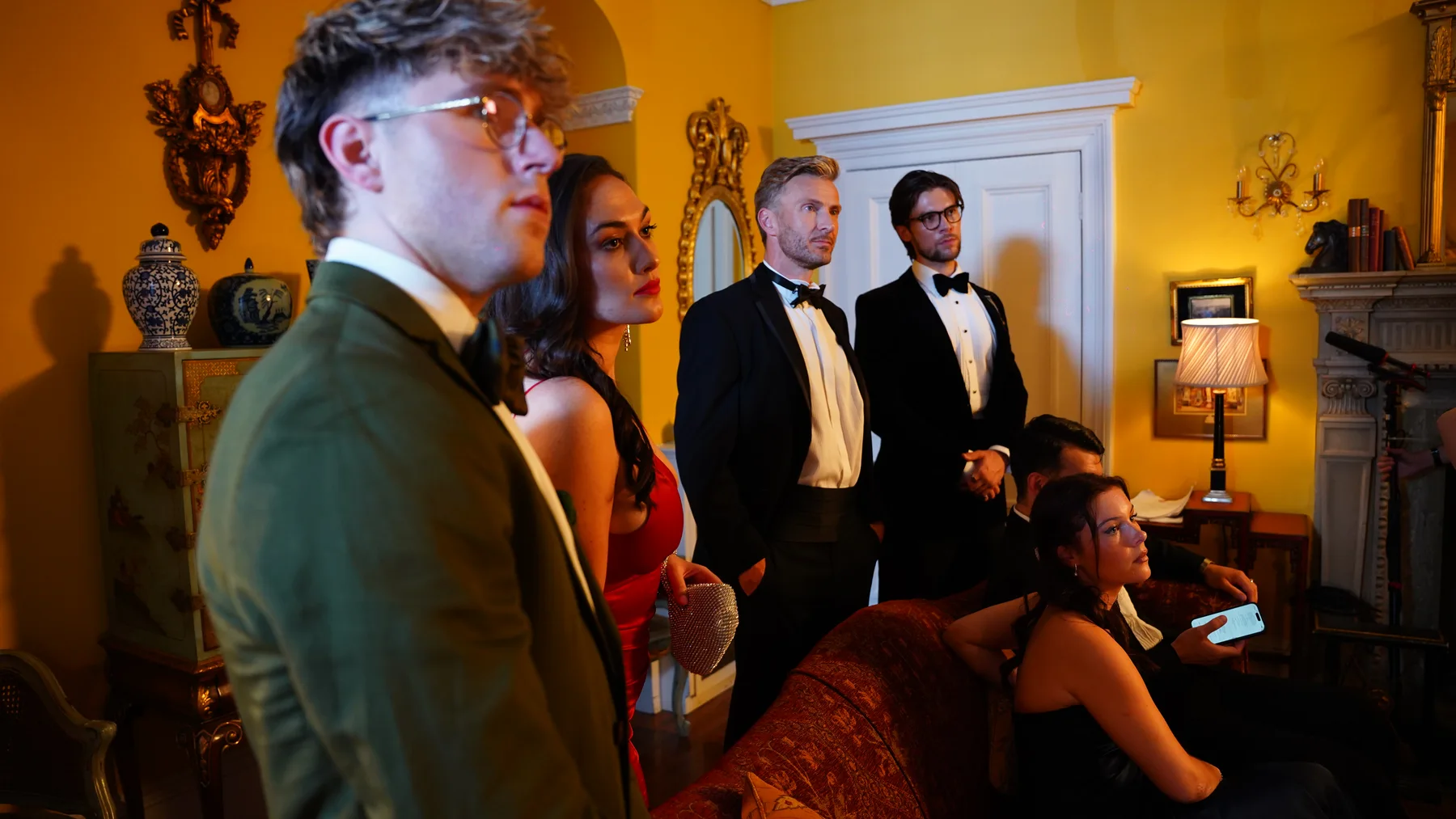 Cast gathered in costume in the manor drawing room