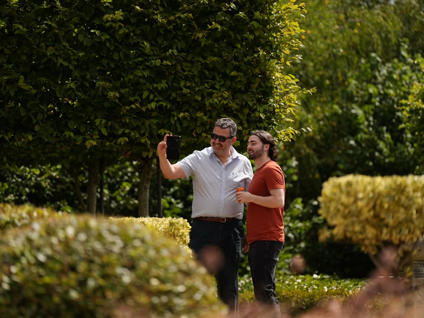Two team members taking a selfie together in the manor gardens