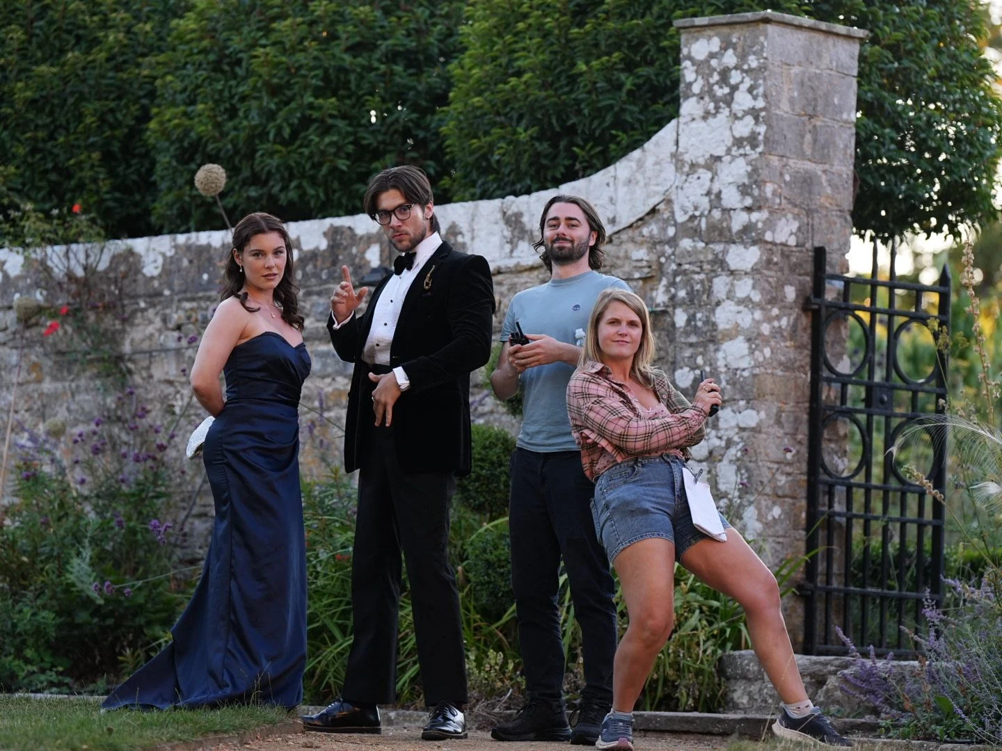 Murder at Macintosh Manor cast and crew together beside a garden gate in Wales